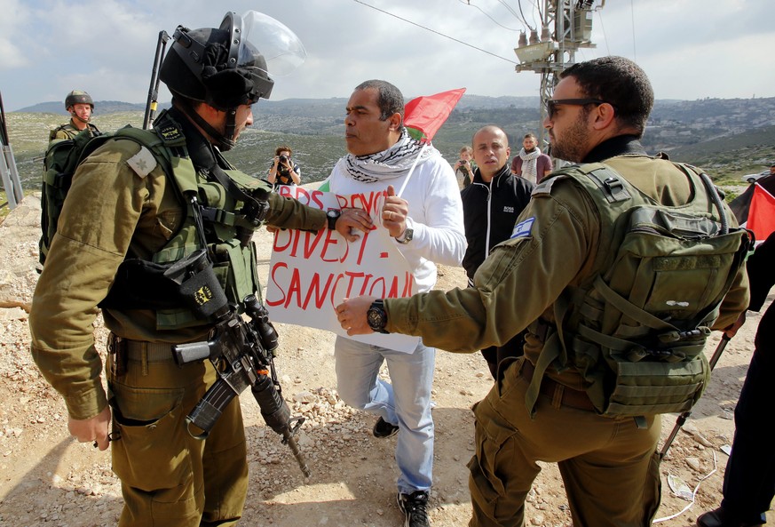 epa04662059 Israeli Border Police and army soldiers block Palestinian protesters from advancing near the southern West Bank village of Jab&#039;a, 14 March 2015. The protesters carried posters referri ...