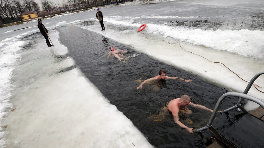 epa05136944 Winter swimming enthusiasts take a bath in the cold waters of a lake at the Victory Park in St. Petersburg, 31 January 2016, during the usual weekend ice-swimming session. EPA/ANATOLY MALT ...