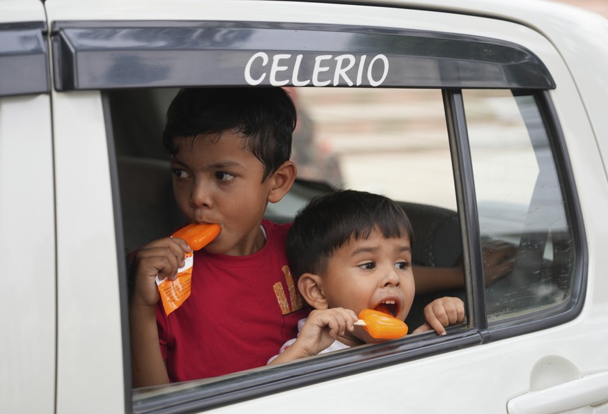 Children eats ice cream sitting in a car in Prayagraj, in the northern Indian state of Uttar Pradesh, Wednesday, April 13, 2022. An unusually early heat wave has brought more triple-digit temperatures ...