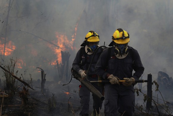 Fire brigade members work to put out fires in Apui, Amazonas state, Brazil, Wednesday, Sept. 21, 2022. The Brazilian Amazon recorded more fires in the first week of September alone than in the whole o ...
