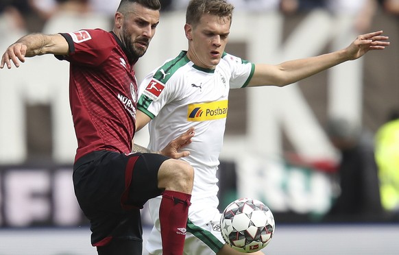 Nuernberger's Mikael Ishak, left, and Matthias Ginter of Borussia Moenchengladbach challenge for the ball during the German Bundesliga soccer match between 1. FC Nuremberg and Borussia Moenchengladbac ...