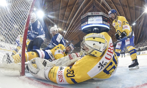 Minsk&#039;s Evgeny Kovyrshin and Rob Klinkhammer fight for the puck with Davos&#039; Beat Forster, goalkeeper Melvin Nyffeler, and Per Ledin, from left, during the game between HK Dinamo Minsk and HC ...