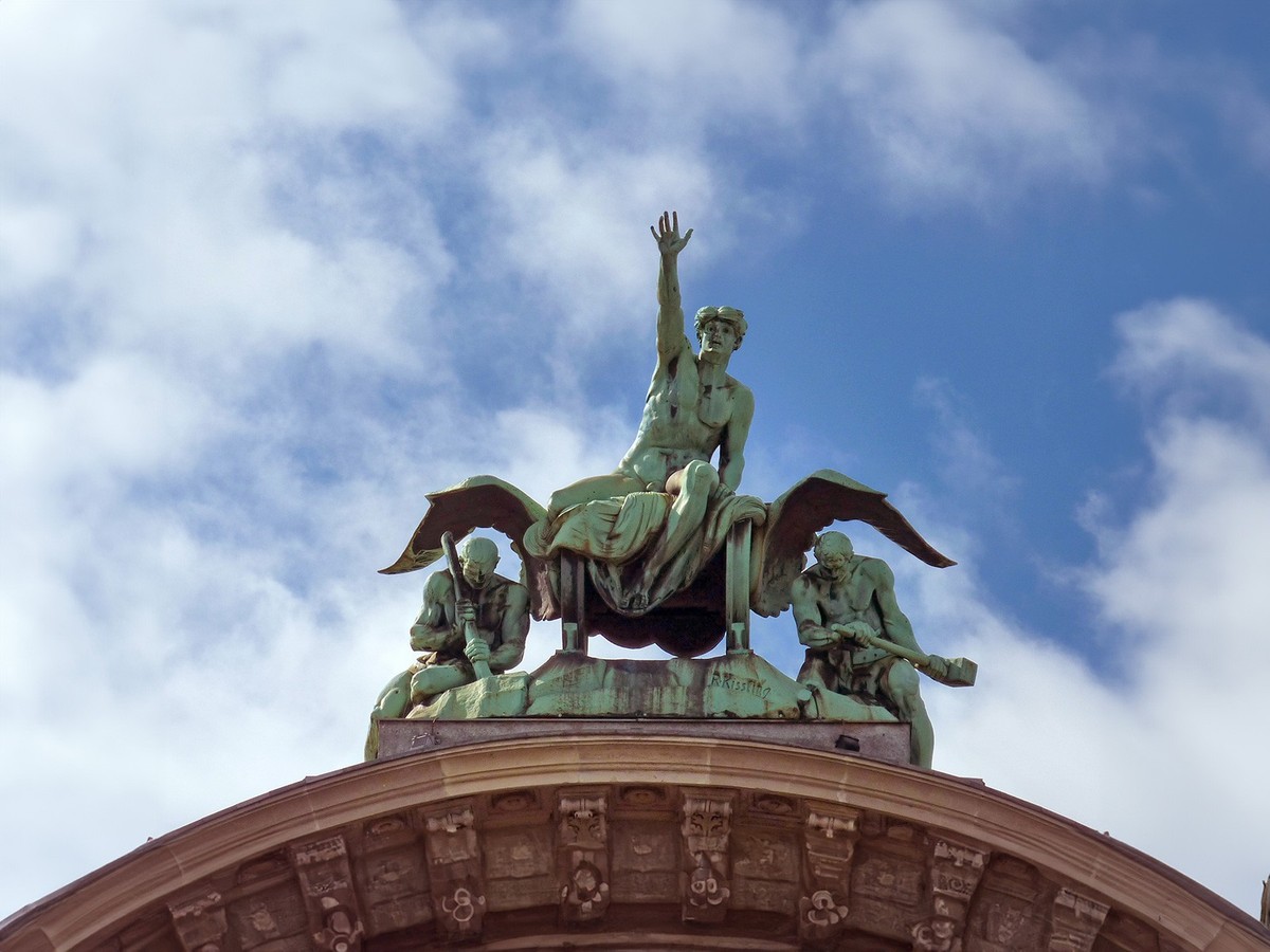 Zeitgeist, 1907 geschaffen von Richard Kissling für den Torbogen des 1896 erbauten Luzerner Bahnhofs. Kühn greift die allegorische Figur auf dem Schienengefährt nach der Zukunft. Die Vergangenheit rei ...