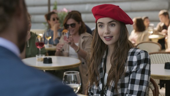 This image released by Netflix shows Lily Collins in a scene from the series "Emily in Paris," premiering on Friday. (Netflix via AP)