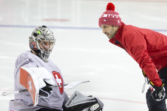 Switzerland's goaltender Reto Berra, left, talks to Thomas Baeumle, right, goaltender coach of Switzerland national ice hockey team, during a Swiss training session, at the IIHF 2021 World Championshi ...
