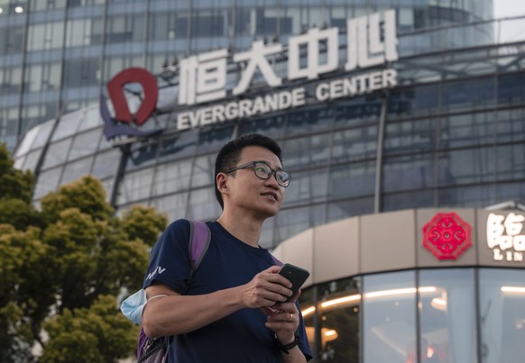 epa09479219 A man walks past the Evergrande Center in Shanghai, China, 21 September 2021. Evergrande Group is China?s real estate conglomerate and the world?s most indebted property developer. Stock m ...