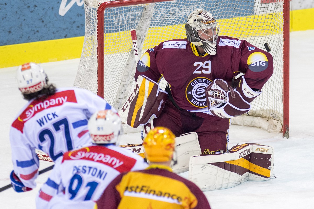 Le joueur zurichois, Roman Wick, gauche, a la lutte pour le puck avec le gardien Genevois, Robert Mayer, droite, lors du match du championnat suisse de hockey sur glace de National League LNA, entre l ...