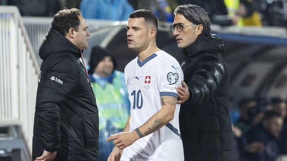 Switzerland's Granit Xhaka, left, and Switzerland's head coach Murat Yakin, right, during the FIFA 2026 World Cup Group B qualifying soccer match between Kosovo and Switzerland, at the stadi ...