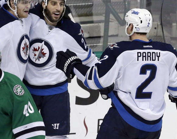 Winnipeg Jets left wing Adam Lowry (17) celebrates his goal with teammates Chris Thorburn (22) and Adam Pardy (2) as Dallas Stars goalie Jussi Rynnas (40) skates off during the second period of an NHL ...