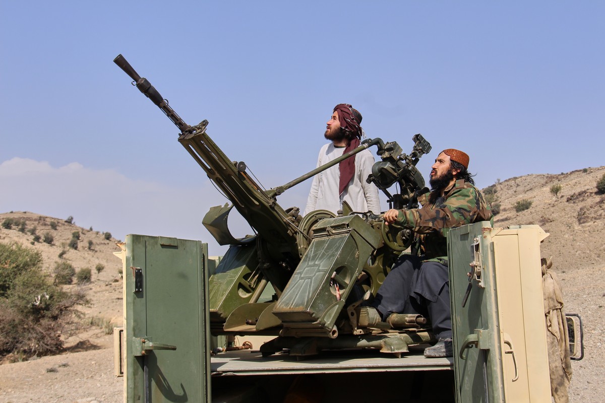 Taliban fighters look up while manning an armed pickup truck at the Afghan side of the Ghulam Khan crossing with Pakistan in Khost province, Afghanistan, Friday, Feb. 27, 2026. (AP Photo/Saifullah Zah ...