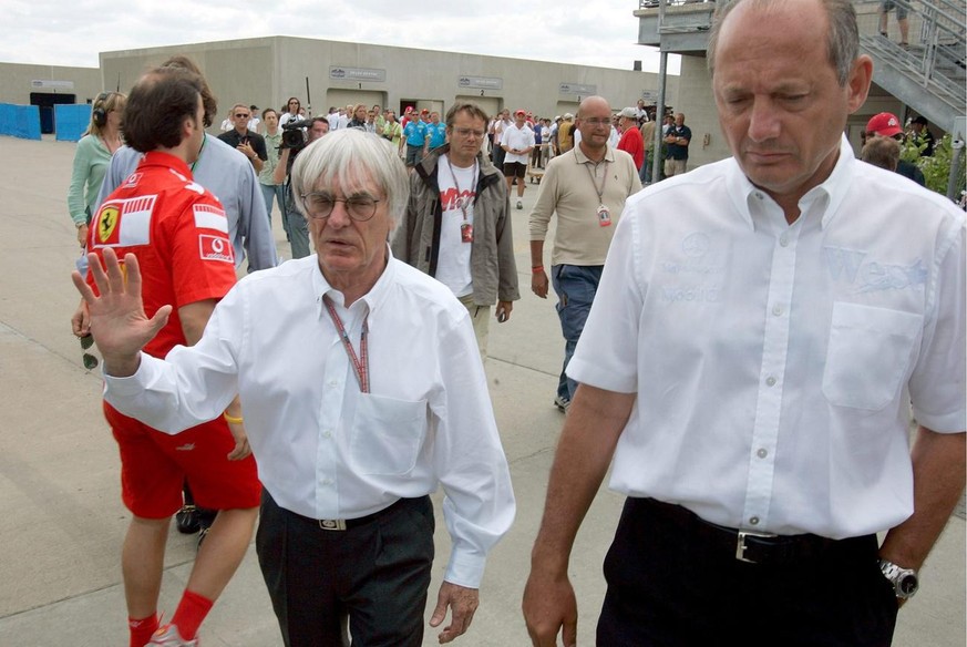 F1 Boss Bernie Ecclestone (L) and McLaren Boss English Ron Dennis (R) walk away after a race security meeting after the Michelin tyre problems before the start of the US Grand Prix at race track in In ...