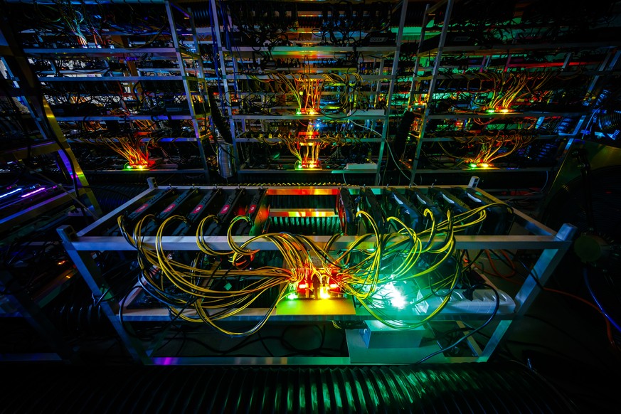 Racks of graphic cards and cryptocurrency mining equipment are lit by the LED status lights of electronic boards during a long exposure photograph at a cryptocurrency mine in the small alpine village  ...