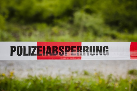 Ein Absperrband mit der Aufschrift Polizeisperrung im Huerstwald, am Donnerstag, 5. Mai 2022 in Zuerich. Die Kantonspolizei Zuerich sperrte den Huerstwald im Zusammenhang mit einem Strafverfahren teil ...