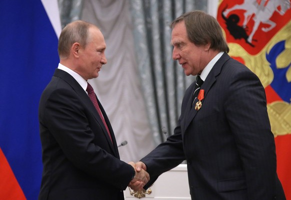 MOSCOW, RUSSIA - SEPTEMBER 22, 2016: Russia s President Vladimir Putin (L) awards Russian cellist Sergei Roldugin, artistic director of the St Petersburg House of Music, with an Order of Alexander Nev ...