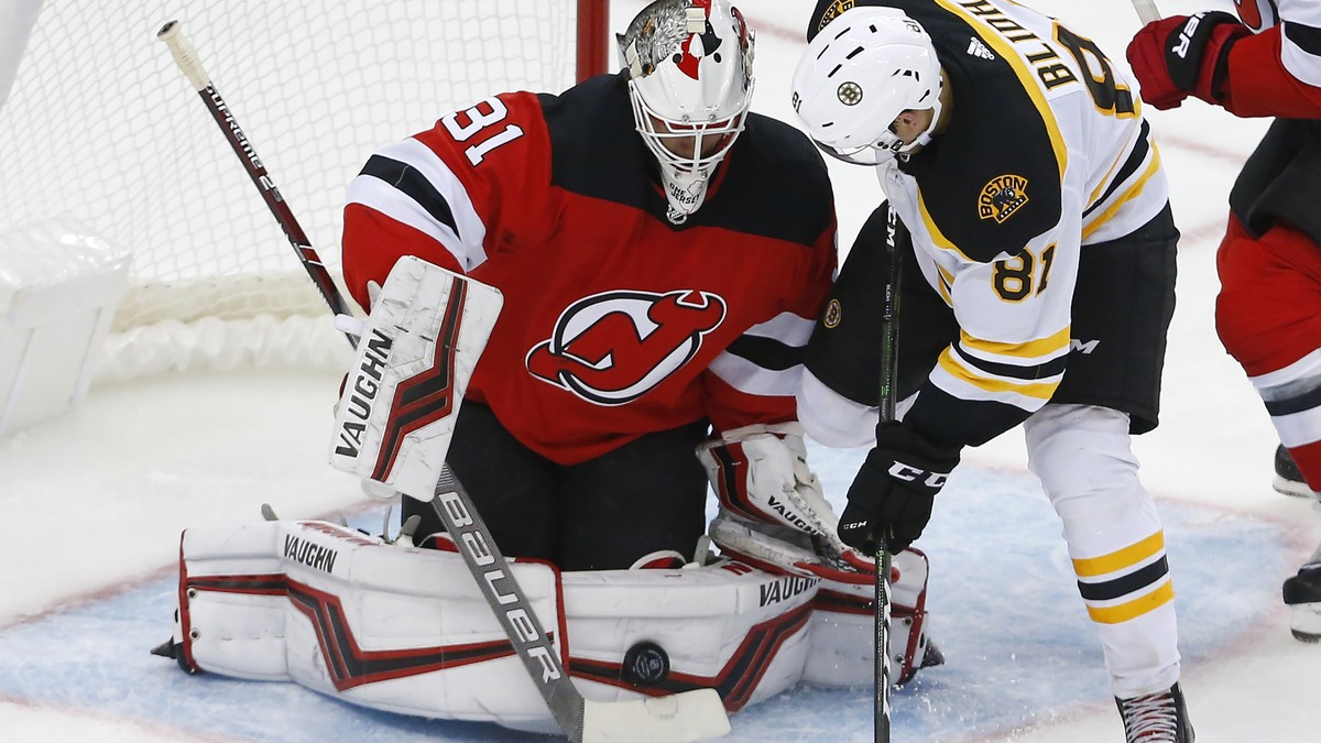New Jersey Devils goaltender Gilles Senn (31) makes a save against Boston Bruins left wing Anton Blidh (81) during the third period of an NHL preseason hockey game, Monday, Sept. 16, 2019, in Newark,  ...
