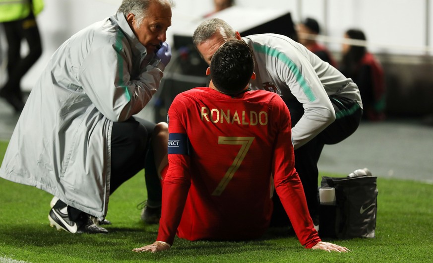 epa07463442 Portugal&#039;s Cristiano Ronaldo (C) receives medical assistance during the UEFA EURO 2020 Group B qualifying soccer match between Portugal and Serbia, at Luz Stadium, Lisbon, Portugal, 2 ...