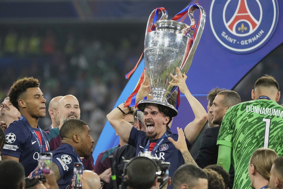 PSG's Vitinha celebrates with the trophy after winning the Champions League final soccer match between Paris Saint-Germain and Inter Milan at the Allianz Arena in Munich, Germany, Saturday, May 3 ...