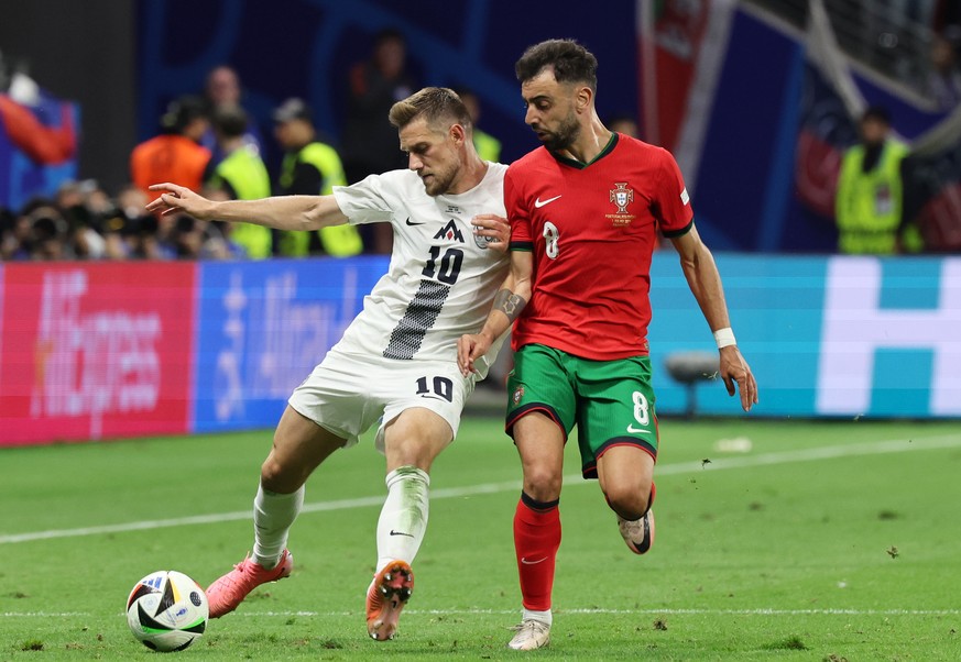 epa11451221 Timi Max Elsnik of Slovenia (L) and Bruno Fernandes of Portugal (R) in action during the UEFA EURO 2024 Round of 16 soccer match between Portugal and Slovenia, in Frankfurt Main, Germany,  ...