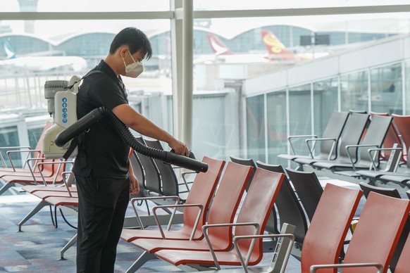 epa08387100 A handout photograph provided by Hong Kong International Airport shows a worker spraying disinfectant in a seating area in Hong Kong International Airport in Hong Kong, China, 24 April 202 ...