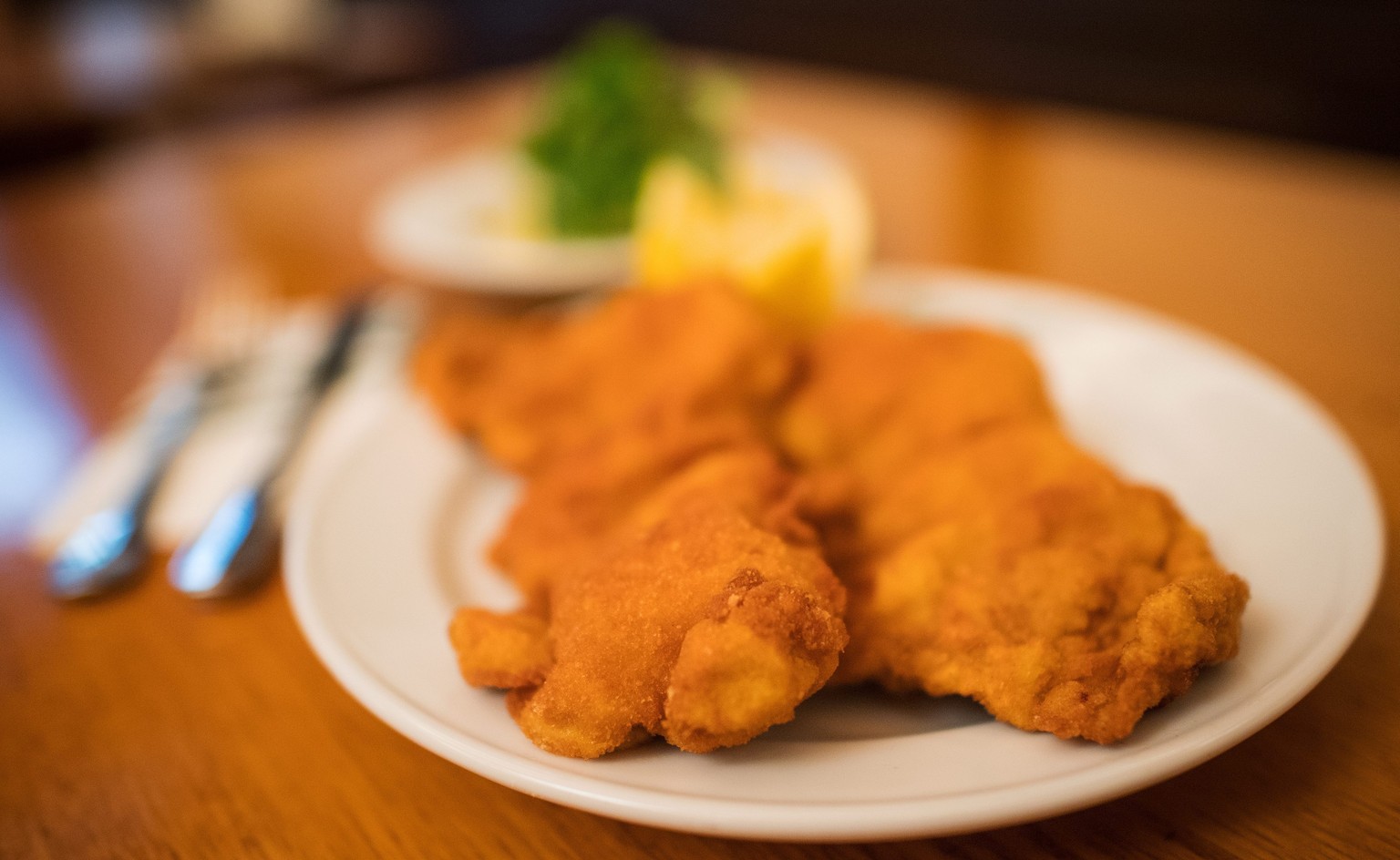 epa05655247 Two Wiener Schnitzel, breaded and fried cutlet, Potato and lamb&#039;s lettuce salad are seen at the Figlmueller restaurant in Vienna, Austria, 01 December 2016. The traditional Viennese r ...