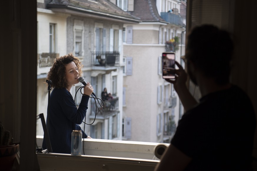epa08329209 Swiss singer and semifinalist of French TV reality show The Voice in 2016 Amandine (Rapin) performs a short concert on her balcony during the state of emergency of the coronavirus disease ...