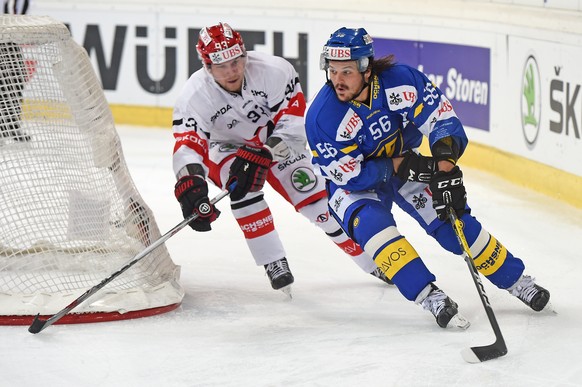 Davos Dino Wieser, right, fights for the puck against Yekaterinburgs Alexei Vasilesvky, left, during the game between Switzerlands HC Davos and Avtomobilist Yekaterinburg at the 90th Spengler Cup ice ...