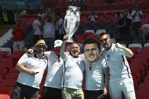 An England fan with a cardboard depicting England&#039;s Harry Maguire poses with other supporters ahead of the Euro 2020 soccer championship group D match between England and Croatia at Wembley stadi ...