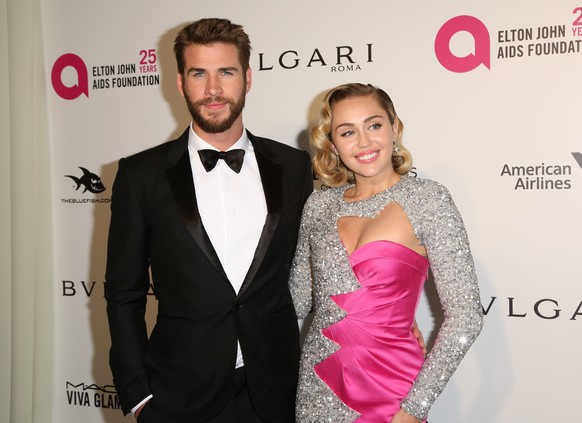 Liam Hemsworth, left, and Miley Cyrus arrive at the 2018 Elton John AIDS Foundation Oscar Viewing Party on Sunday, March 4, 2018, in West Hollywood, Calif. (Photo by Willy Sanjuan/Invision/AP)