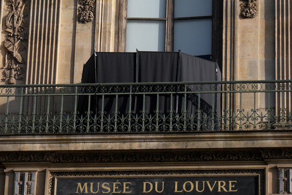 A black curtain hides the window where thieves entered the Louvre museum, three days after historic jewels were stolen in a daring daylight heist, Wednesday, Oct. 22, 2025 in Paris. (AP Photo/Thibault ...