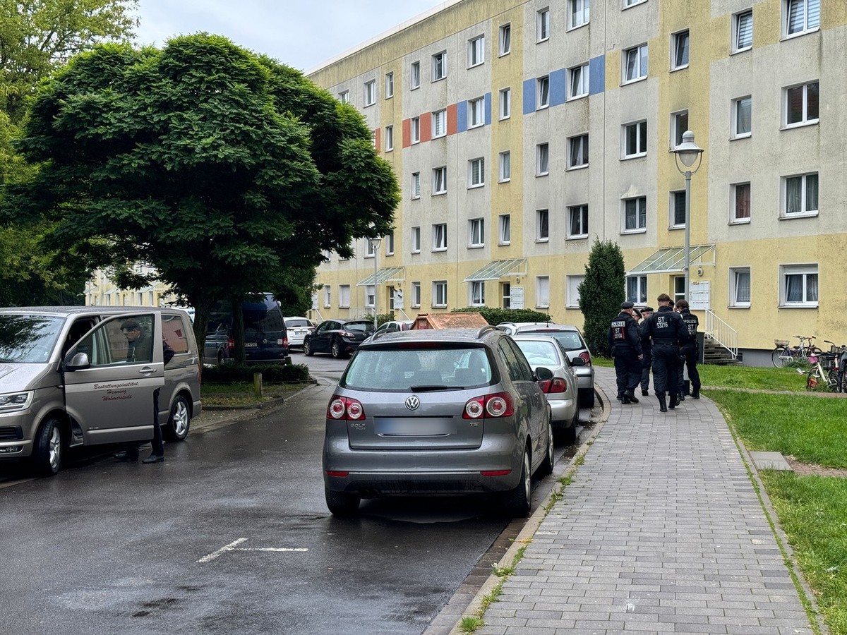 15.06.2024, Sachsen-Anhalt, Wolmirstedt: Polizisten und ein Fahrzeug eines Bestattungsunternehmen stehen in der N
