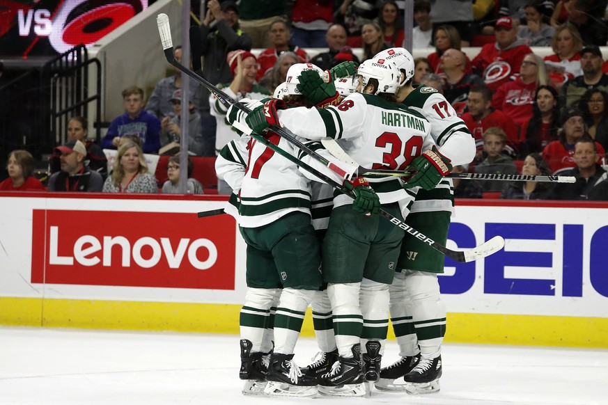 Minnesota Wild players celebrate a goal against the Carolina Hurricanes during the first period of an NHL hockey game in Raleigh, N.C., Saturday, April 2, 2022. (AP Photo/Karl B DeBlaker)