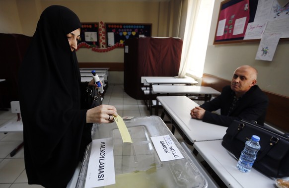 epa05910917 A veiled woman casts her vote at a polling station for a referendum on the constitutional reform in Istanbul, Turkey, 16 April 2017. The proposed reform, passed by Turkish parliament on 21 ...