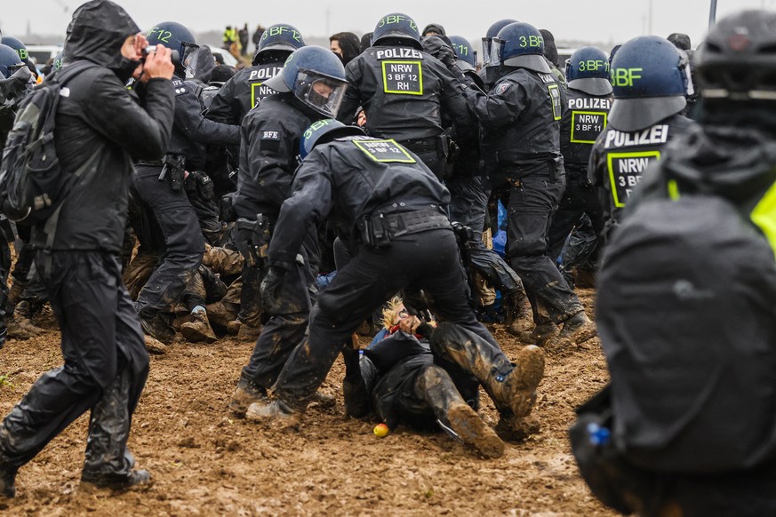 epa10404875 Policemen clash with protesters during a rally of climate protection activists near the village of Luetzerath, Germany, 14 January 2023. The village of Luetzerath in North Rhine-Westphalia ...