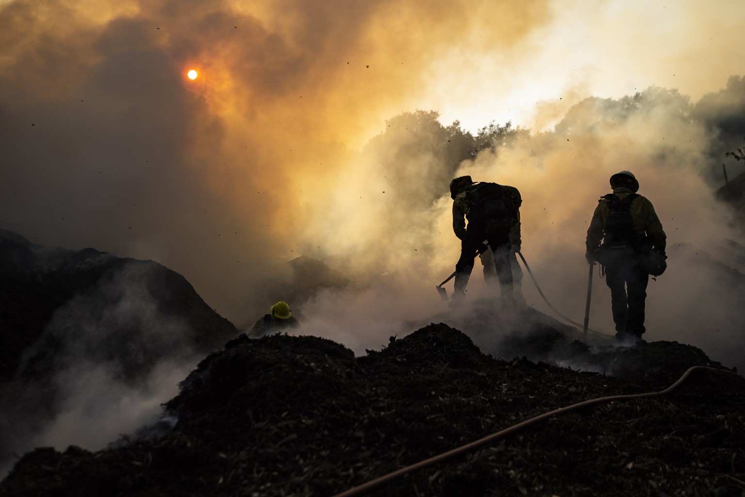 epa07916531 Firefighters work to extinguish the Saddleridge Fire burning in the hills between Sylmar and Santa Clarita, California, USA, 12 October 2019. According to the latest reports evacuation ord ...