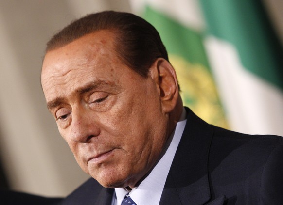 FILE - In this Saturday, Feb. 15, 2014 file photo Silvio Berlusconi talks to journalists after talks with Italian President Giorgio Napolitano, at the Quirinale presidential palace, in Rome. A Milan c ...