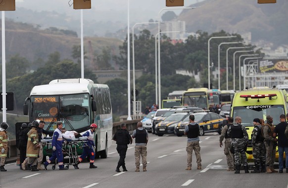 epa07782076 A woman is taken on a stretcher after she passed out moments after she was released from a bus by a hijacker in the Rio-Niteroi bridge in Rio de Janeiro, Brazil, 20 August 2019. A masked a ...