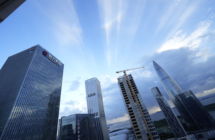 The Evergrande headquarters, left, stands in Shenzhen, China, Friday, Sept. 24, 2021. Seeking to dispel fears of financial turmoil, some Chinese banks are disclosing what they are owed by a real estat ...