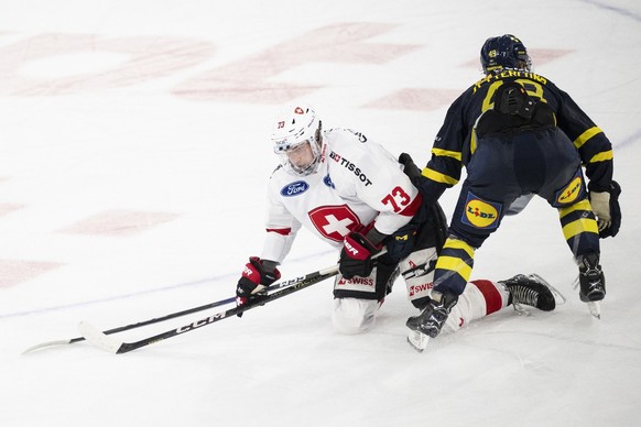 Switzerland&#039;s Mike Kuenzle, left, in action against Sweden&#039;s Fabian Zetterlund, right, during the Breakout-Game of the Betano Hockey Games between Switzerland and Sweden at the stimo Arena i ...