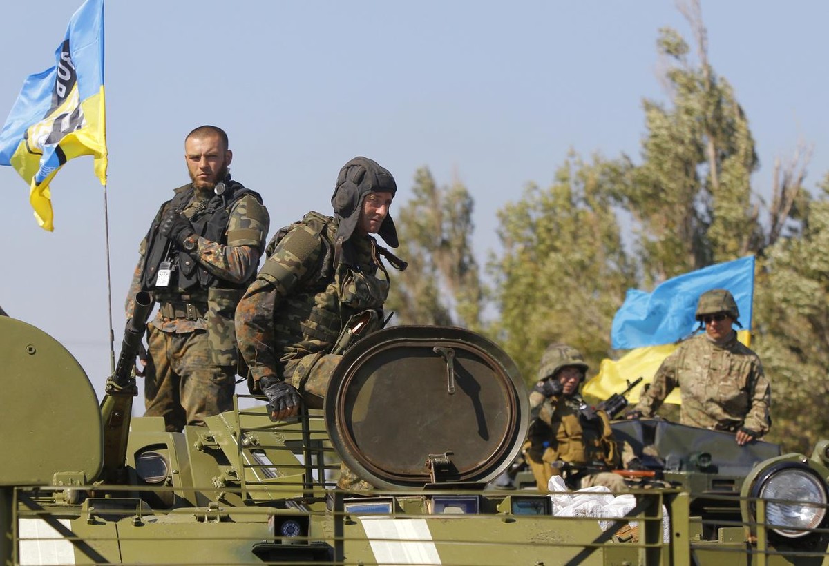 Soldiers of special battalion "Azov" sit in an APC at a checkpoint in the port city of Mariupol, southeastern Ukraine, Friday, Sept. 5, 2014. The Ukrainian president declared a cease-fire Fr ...