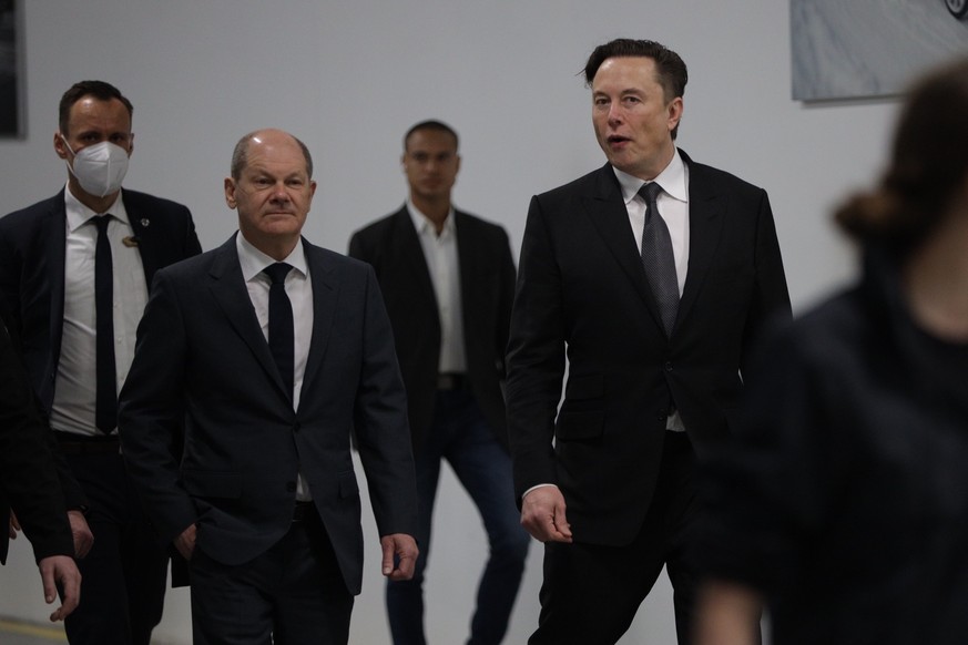 epa09842292 Tesla CEO Elon Musk (R) and German Chancellor Olaf Scholz (L) at the opening day of the Tesla &#039;Gigafactory&#039; in Gruenheide near Berlin, Germany, 22 March 2022. EPA/CHRISTIAN MARQU ...
