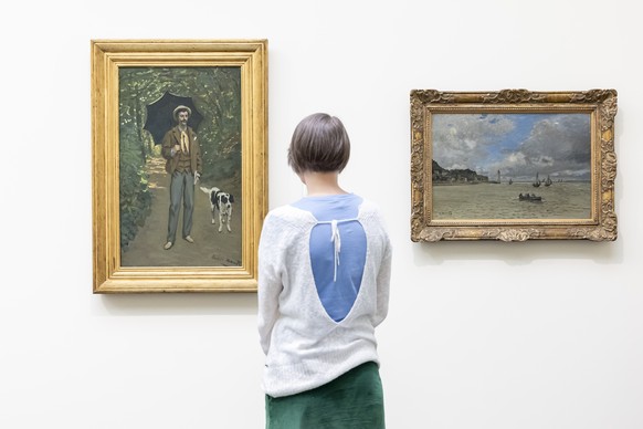 Eine Frau betrachtet das Werk &quot;L&#039;Homme a l&#039;ombrelle&quot; von Claude Monet, links, neben dem Werk &quot;Le phare de Honfleur&quot; von Claude Monet, rechts, im Kunsthaus Zuerich, am Don ...
