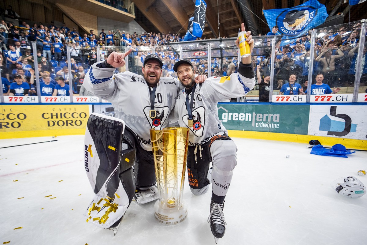 Torhueter Reto Berra und Julien Sprunger (HCFG) feiern den Meistertitel mit dem Pokal nach ihrem Sieg gegen Davos in der Verlaengerung im siebten Eishockey Playoff Finalspiel der National League zwisc ...