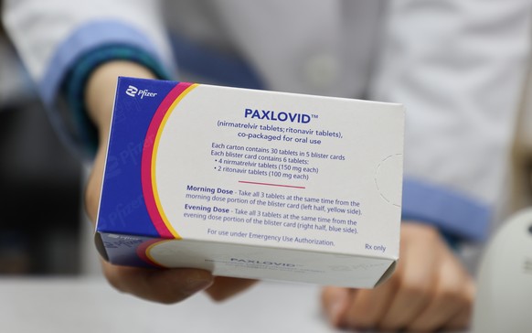 epa09775282 A pharmacist displays a case of Paxlovid, a COVID-19 treatment pills developed by Pfizer Inc., at a drugstore in Seoul, South Korea, 21 February 2022. The age restriction on the administra ...