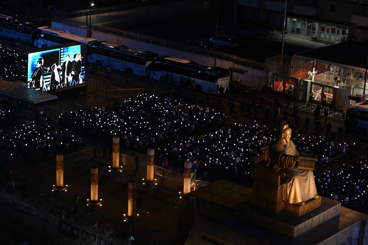 Fans watch the concert of K-pop boy group BTS on a screen in Seoul on March 21, 2026. South Korean megastars BTS reunite on March 21, for their first show in nearly four years, with an expected 260,00 ...