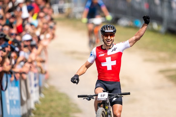 epa10136170 Nino Schurter from Switzerland, 1st, crosses the finish line during the UCI Cross Country Team Relay Mountain Bike World Championship, in Les Gets, France, 24 August 2022. EPA/MAXIME SCHMI ...