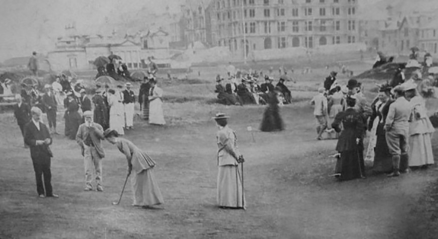 Beobachtet von Old Tom Morris (zweiter von links) golfen einige Frauen in St. Andrews, 1894. https://commons.wikimedia.org/wiki/File:Ladies_Putting_Club_1894_on_The_Himalayas_with_Old_Tom_Morris.jpg