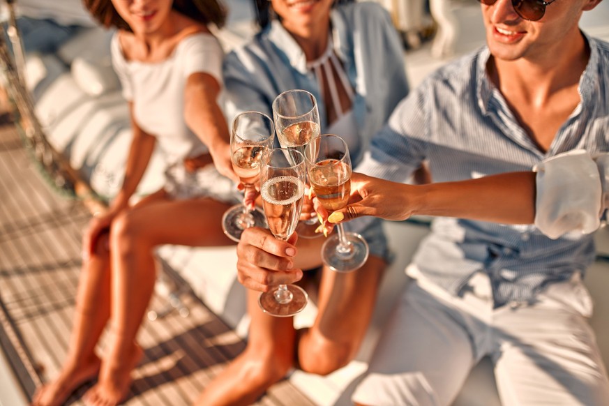 Menschen mit Champagner auf einer Luxusjacht.