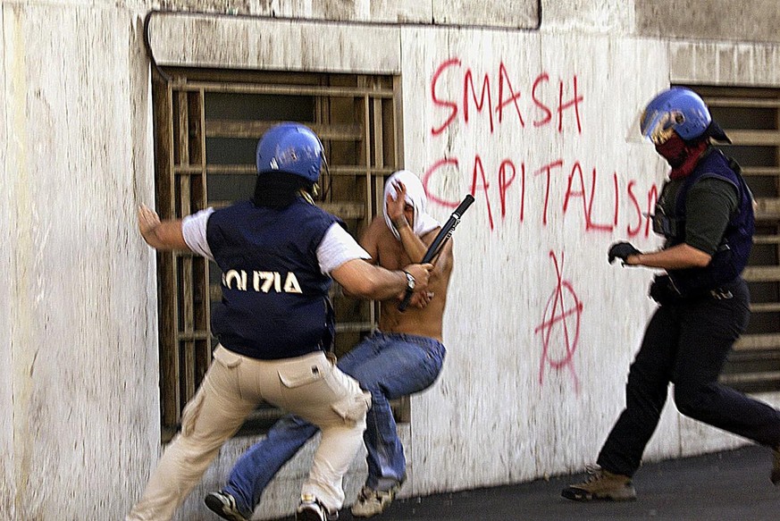 Ein Demonstrant wird an einer G8-Protestdemo in Genua von italienischen Polizisten verprügelt.