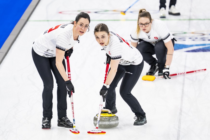 Carole Howald, Selina Witschonke and Alina Paetz of Switzerland, from left to right, in action during the women's curling semi-final game between Switzerland and USA at the 2026 Olympic Winter Ga ...