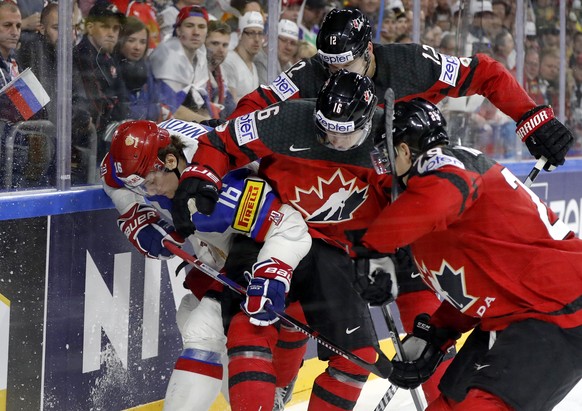 Russia&#039;s Sergei Plotnikov, left, challenges for the puck with Canada&#039;s, from right, Canada&#039;s Nate Mackinnon, Mitch Marner, and Colton Parayko, at the Ice Hockey World Championships semi ...